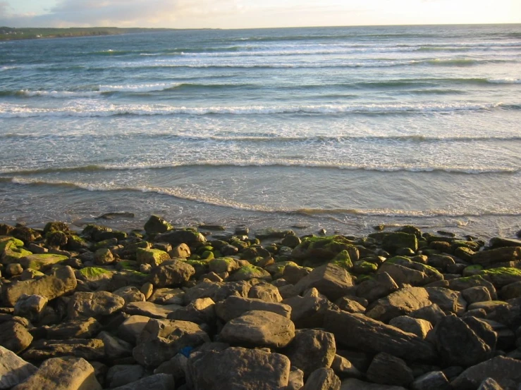 a beach with large rocks covered in water and small waves