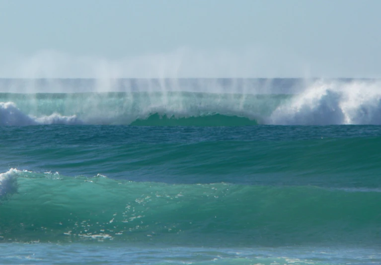 people are riding waves in the ocean