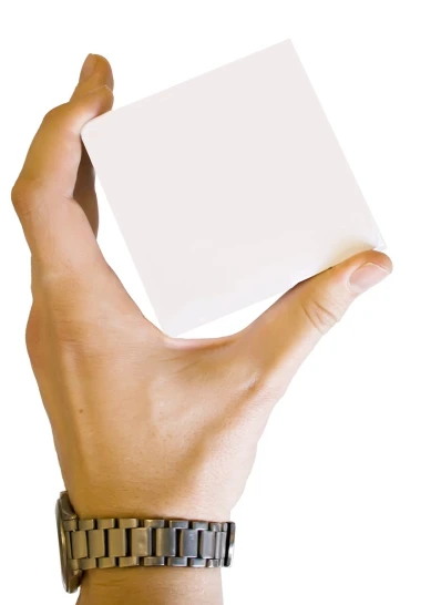 a person's hand holding up a blank card