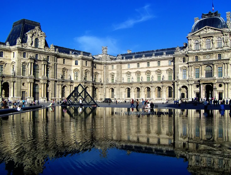 people walking and sitting around a large building