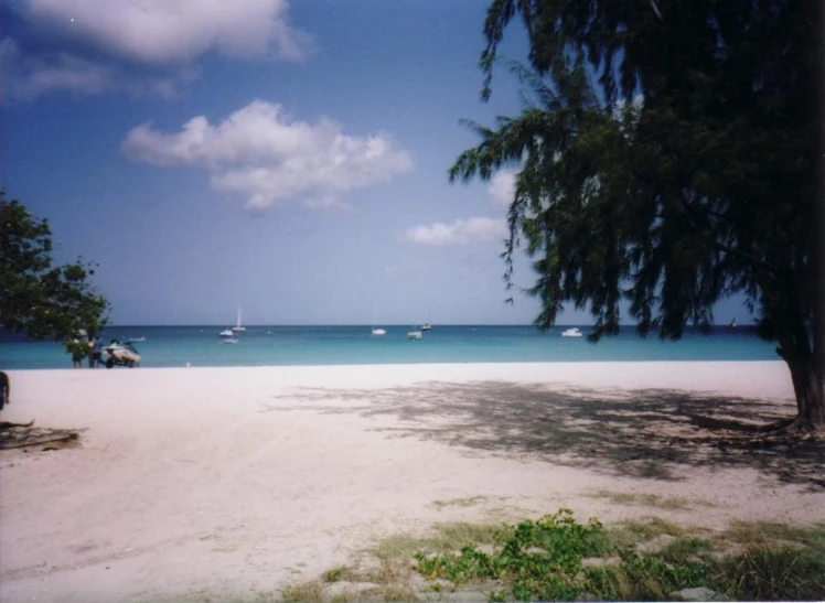 a beach with boats and water near by