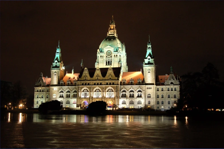 a building with towers at night over water