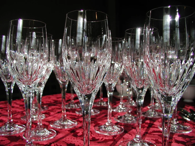 the wine glasses are placed on the red tablecloth