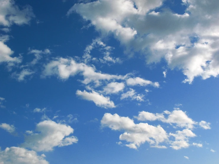 a lone plane is flying across the cloudy sky