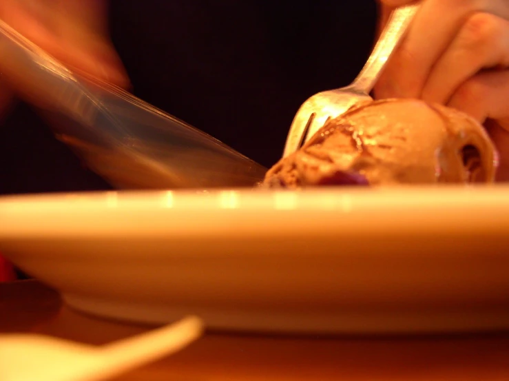 someone uses a knife to cut through some chocolate