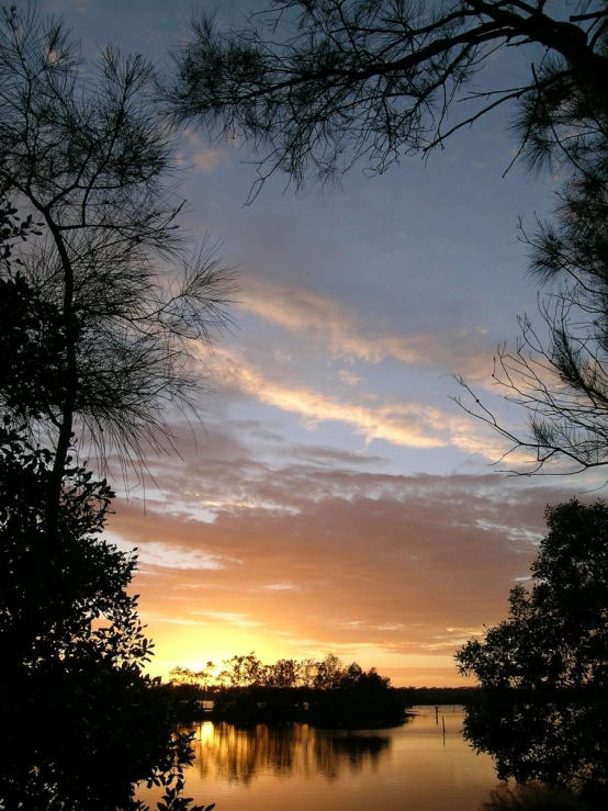 a lake sitting under a sunset filled sky