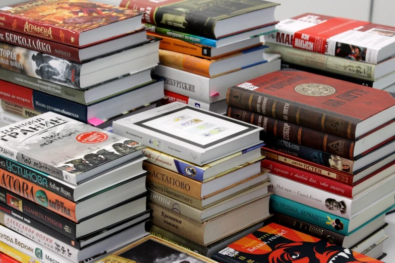 a large pile of books are stacked on top of each other