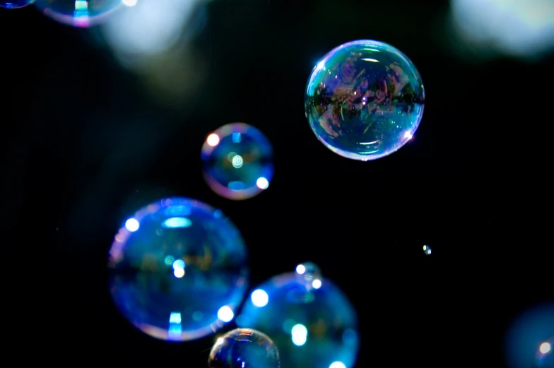 a group of soap bubbles floating through the dark