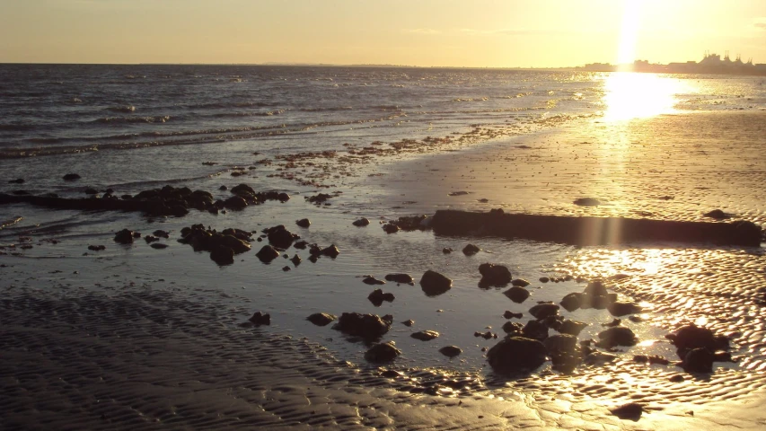 a beach filled with lots of water next to rocks