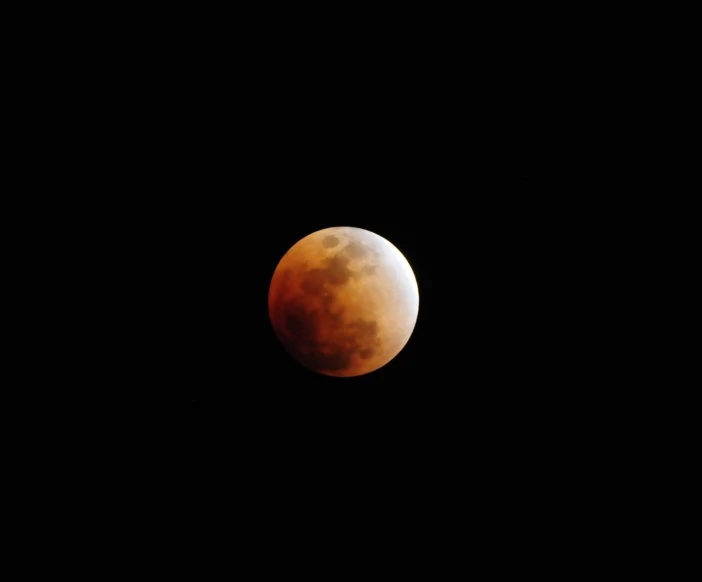 the red moon is seen in the dark sky