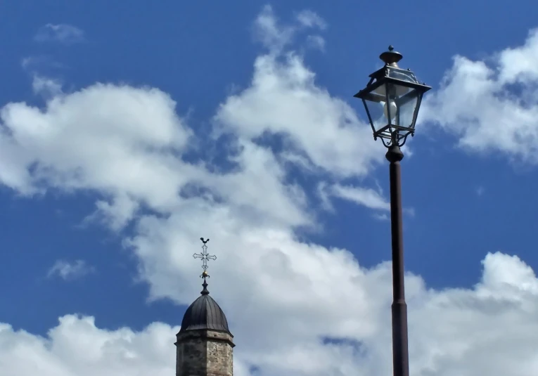 a lamp post and a tower against the blue sky