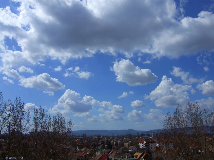 an expansive view of a city from a hill in the afternoon