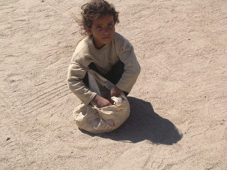 the little girl is playing in the sand