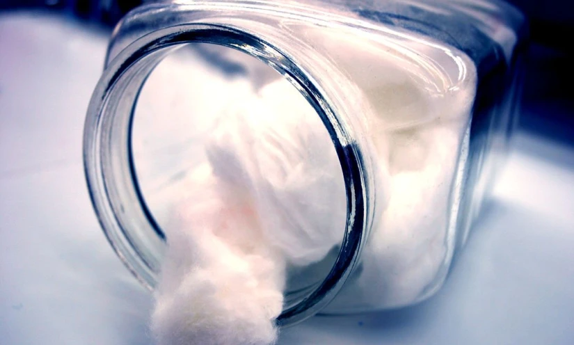 a white fuzzy object sticking out of a mason jar