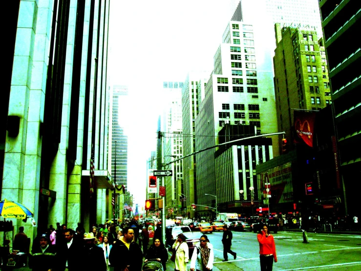 a crowd of people walking down a sidewalk in a city
