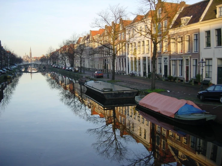 a canal with houses lining both sides and a street below it
