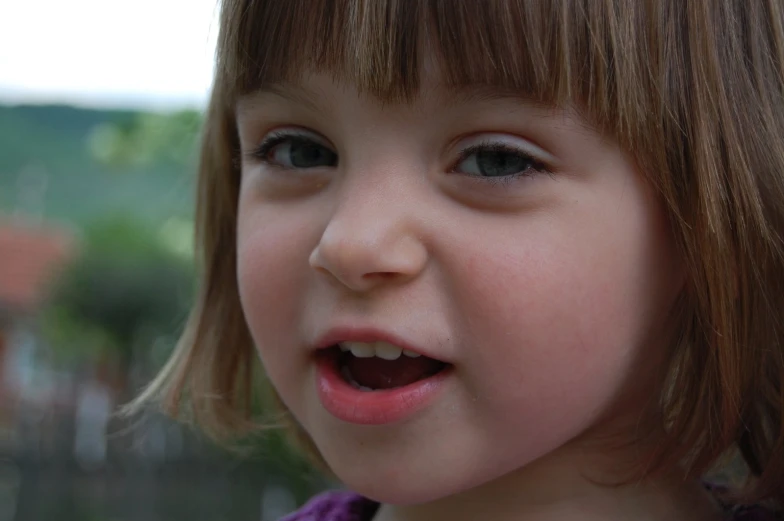 a little girl smiles as she brushes her teeth