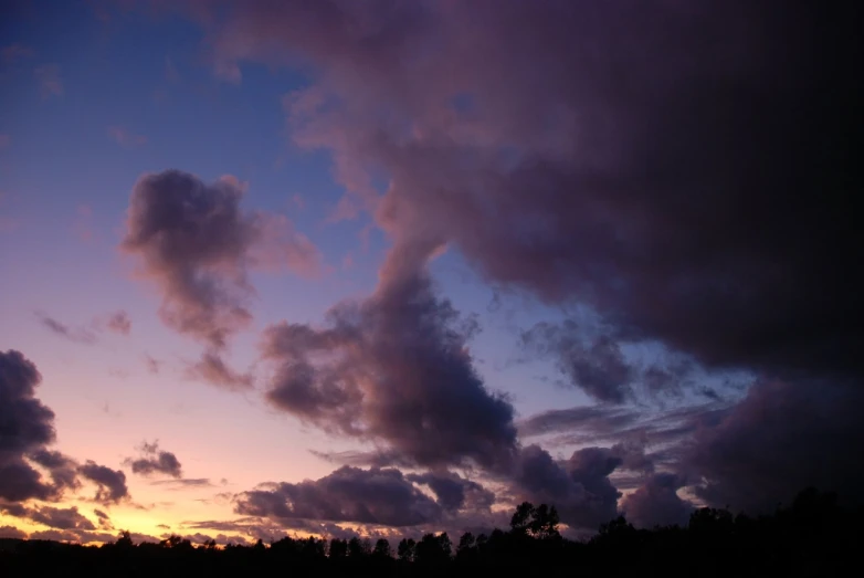 the sky is purple and blue and some clouds