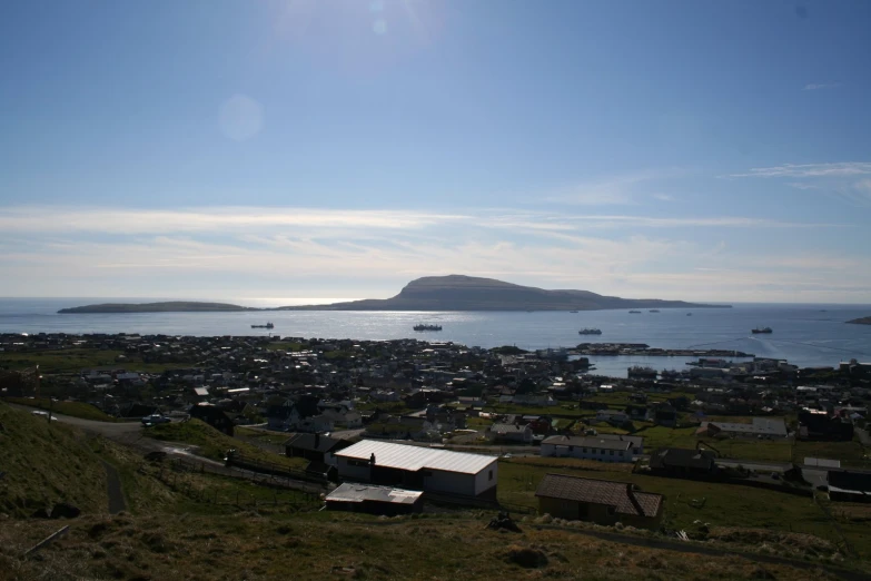 the ocean is calm as it sits in front of small cottages