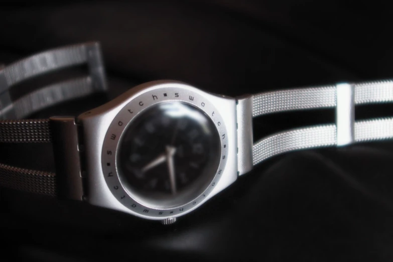 this is a silver watch with a dark background