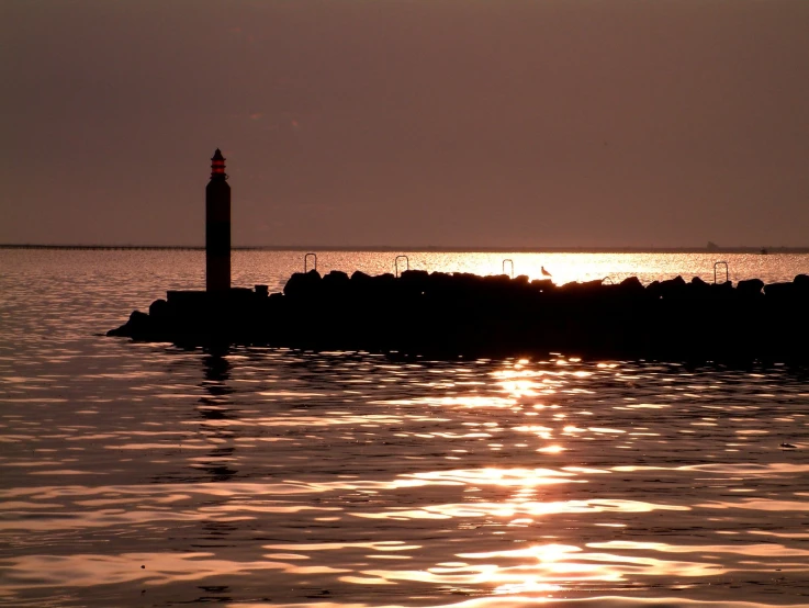 a lighthouse stands in the distance over a body of water