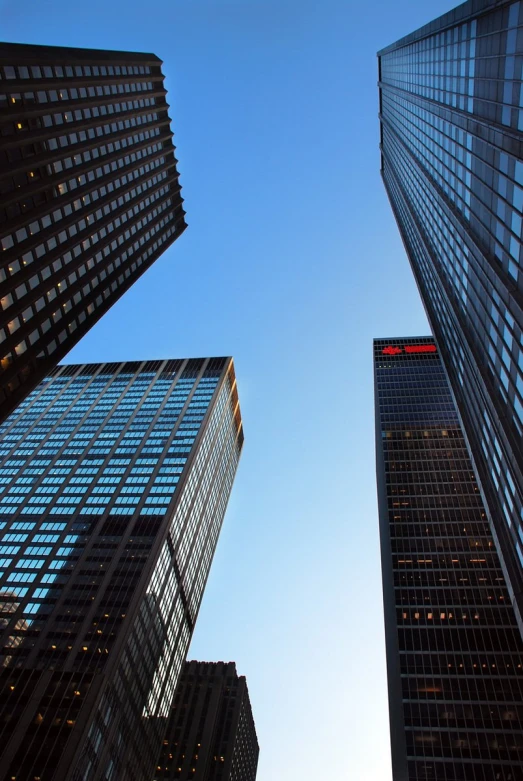 a close up view of tall skyscrs with a bright blue sky in the background