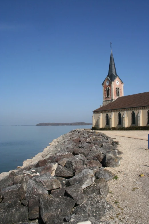 the beach has rocks and a small church