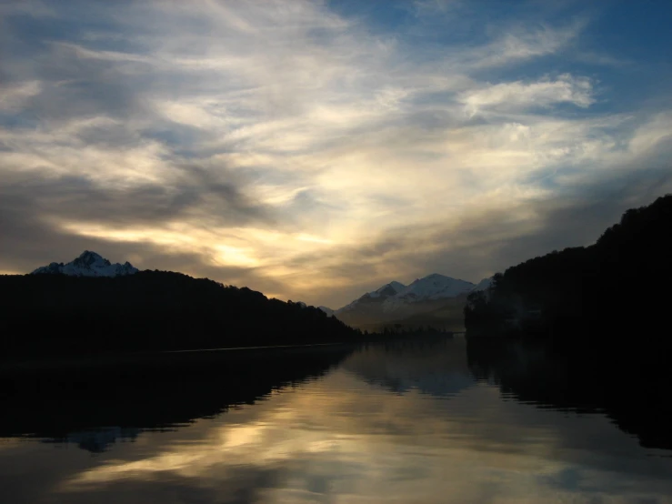 the sun is reflecting off the water and some hills