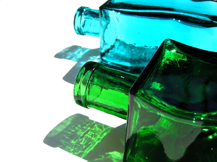the shadows of two green and blue bottles