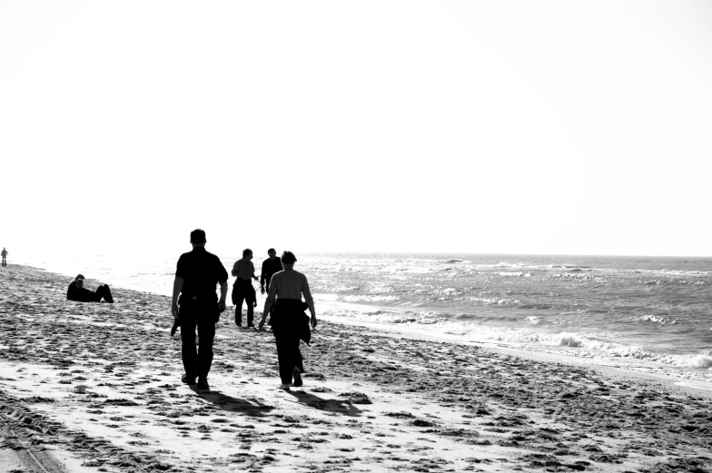 several people walking along a beach near the ocean