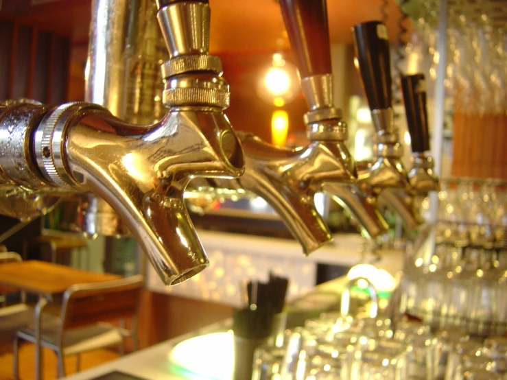 a row of taps are in the front of a beer bar