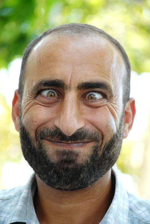 a man in a on up shirt and beard with a smiling face