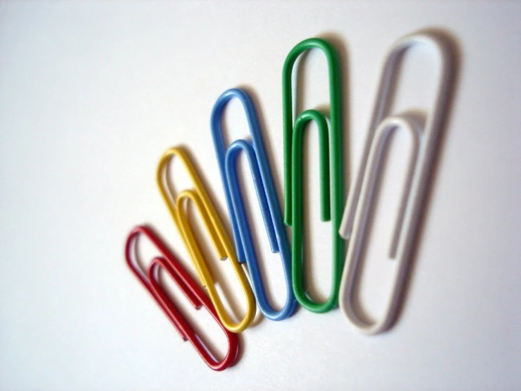 four different colored office clippies sitting next to each other