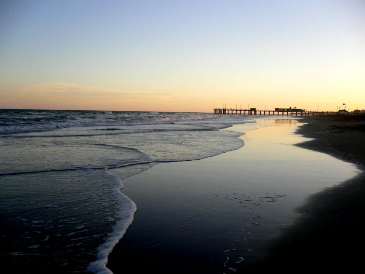 a pier and the beach during sunset