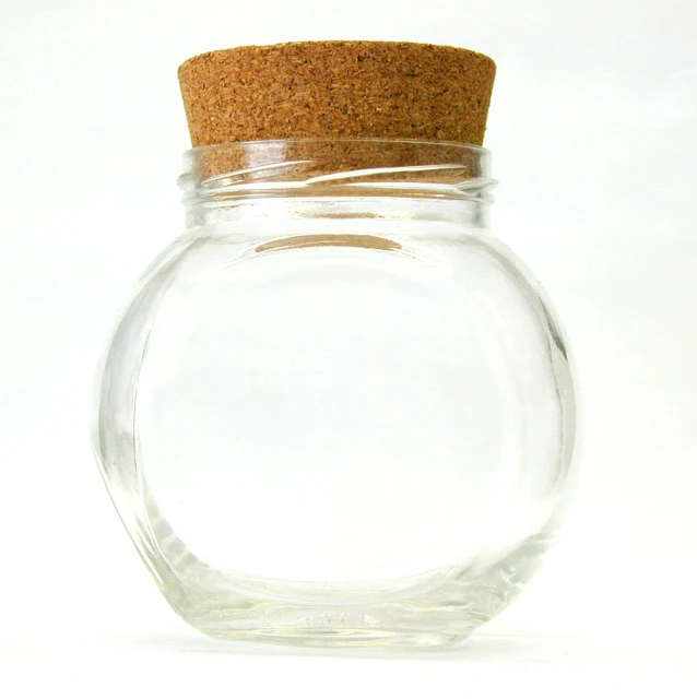 a clear round glass jar with a cork cap