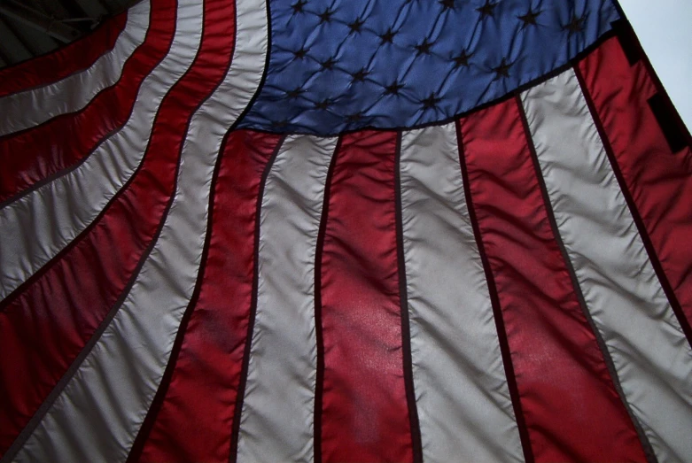 a giant american flag hanging from a pole