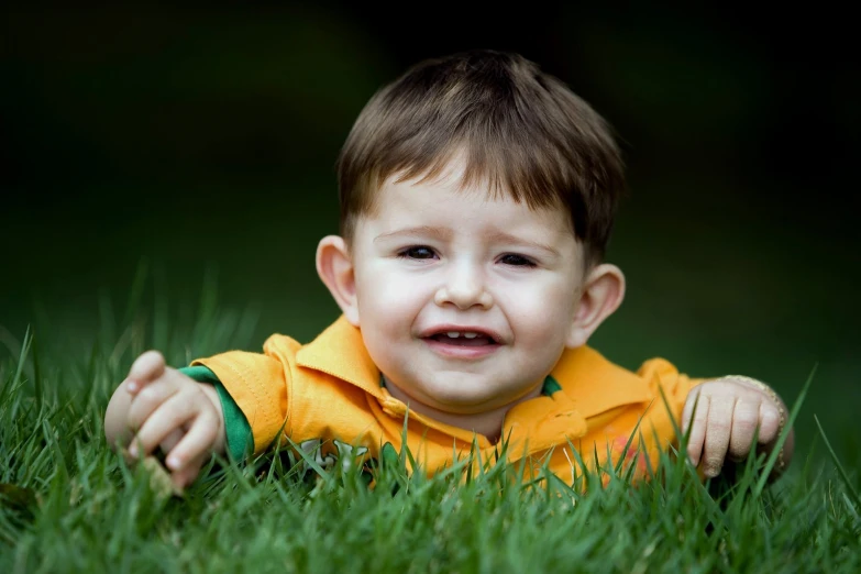 a  sits in the green grass and smiles