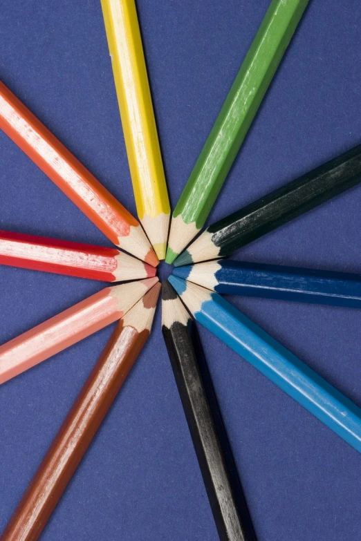 several colored pencils in a circle on a blue background