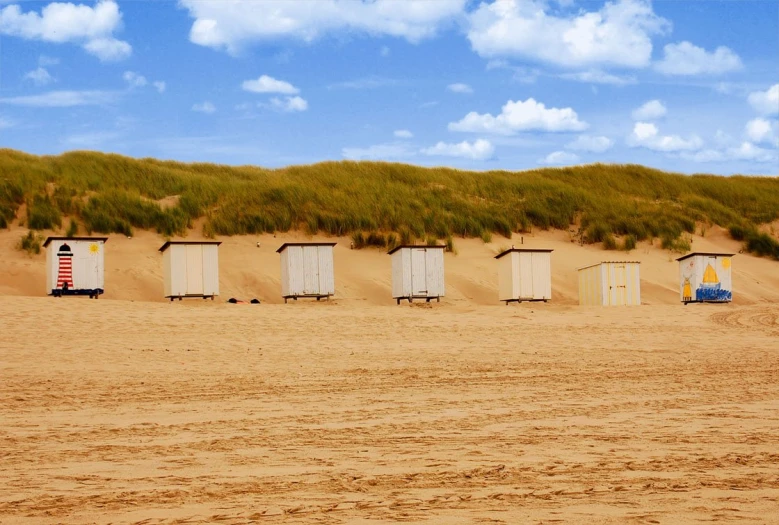 many outhousees on the sand in the distance