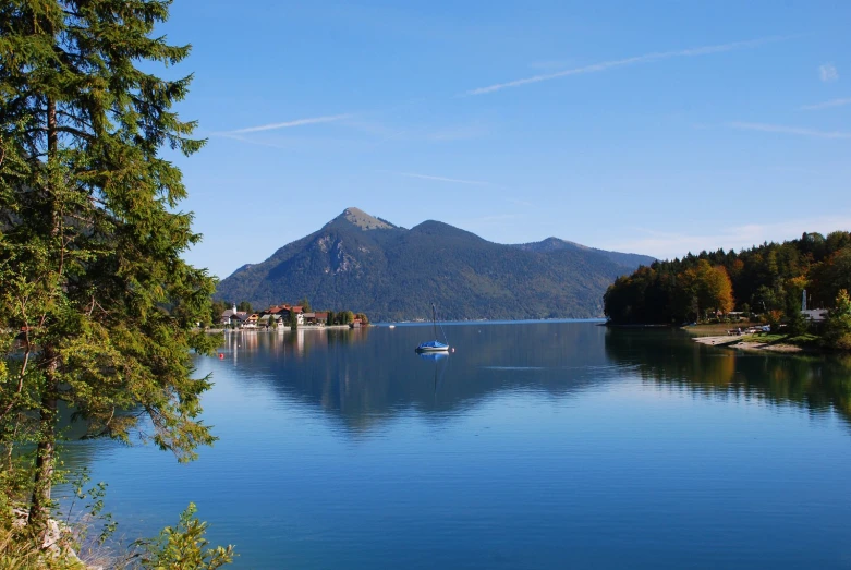 a boat floating on top of a large lake near mountains