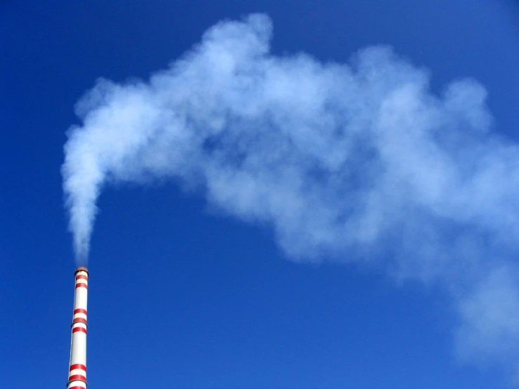 a chimney is emitting smoke into the sky