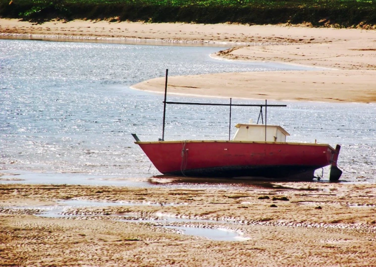 a small boat in the shallow water at the edge of the beach