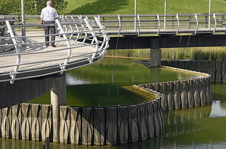 a man stands in the background as he crosses a bridge