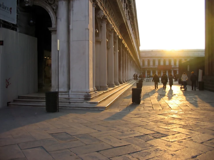 a man walking down a sidewalk in front of an old building