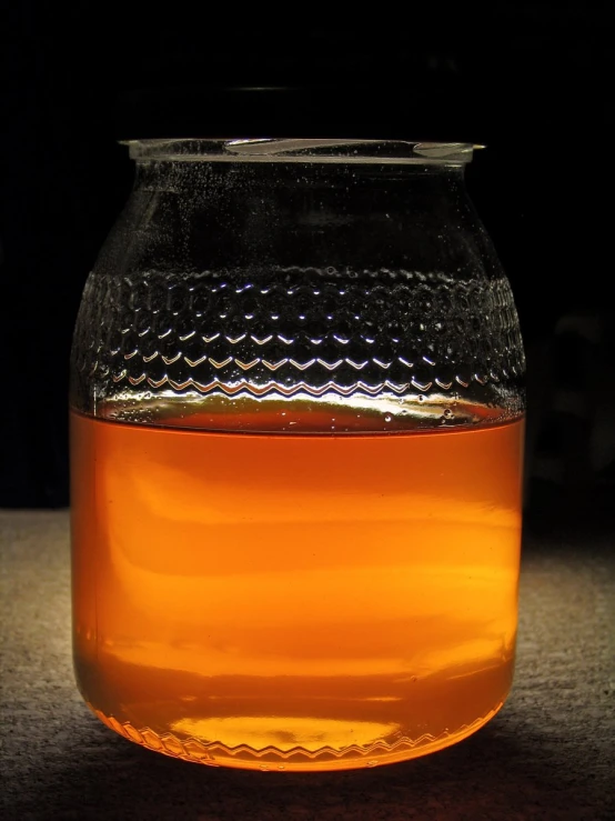 a small jar full of liquid on a table