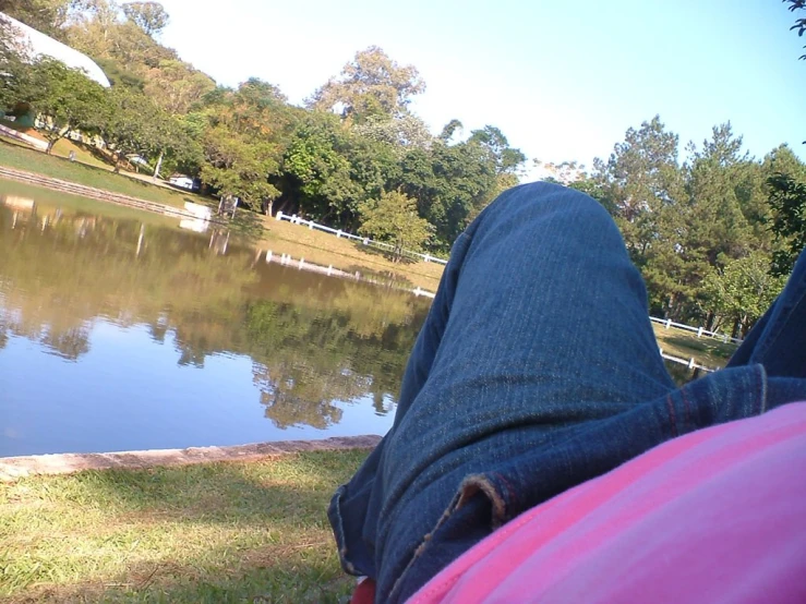 person laying on ground next to body of water