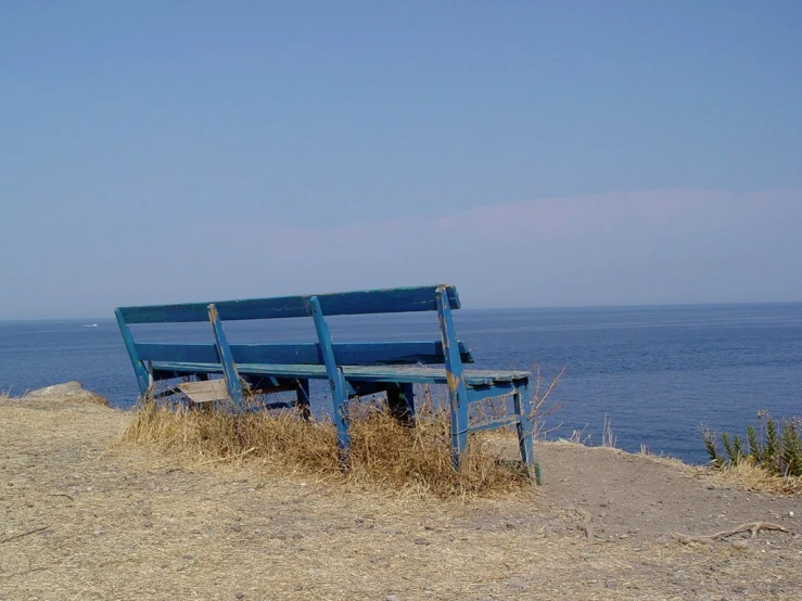 a bench on a cliff near the ocean