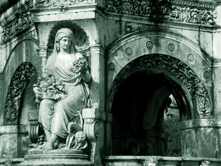 statue of an ornately styled person on the outside of a building