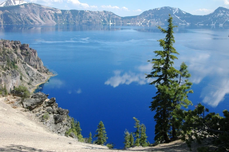 a lake surrounded by trees with a mountain in the background