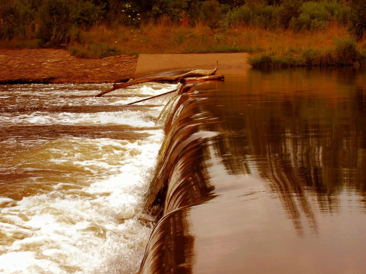 the water is rushing down from a small dam